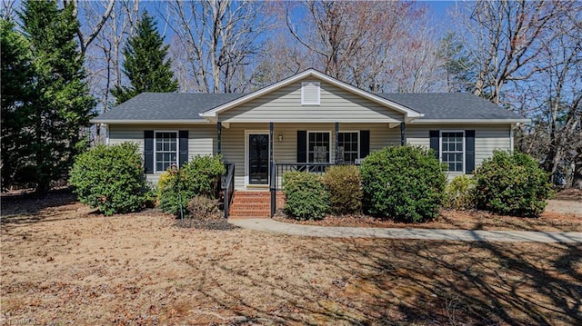 ranch-style house with a porch and roof with shingles