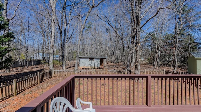 wooden terrace with a fenced backyard, a storage shed, and an outdoor structure