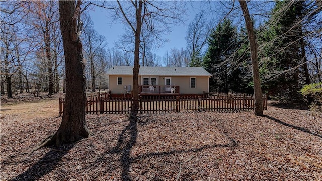 rear view of house featuring a deck and fence