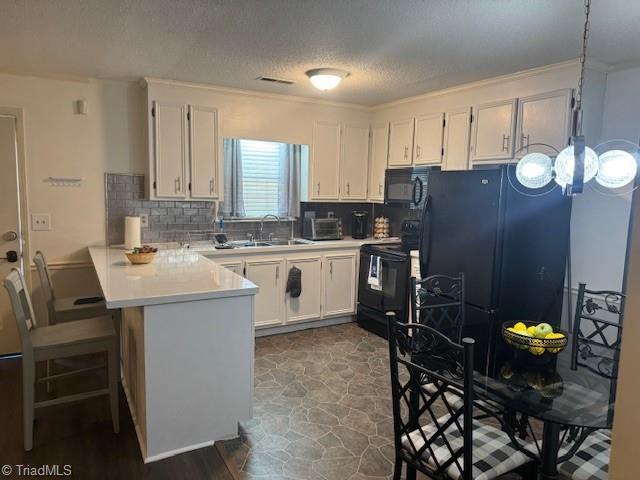 201 Olde Vineyard Ct, Winston-Salem, NC 27104 - kitchen featuring black appliances, a peninsula, white cabinets, light countertops, and backsplash