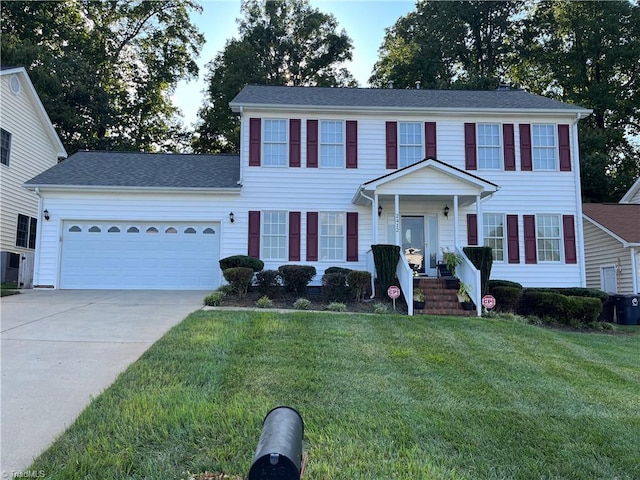 colonial inspired home featuring a garage and a front lawn