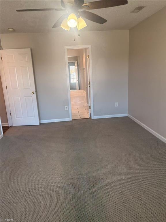 carpeted spare room with ceiling fan and a textured ceiling