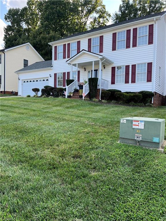 view of front of property with a garage, a front yard, and a porch