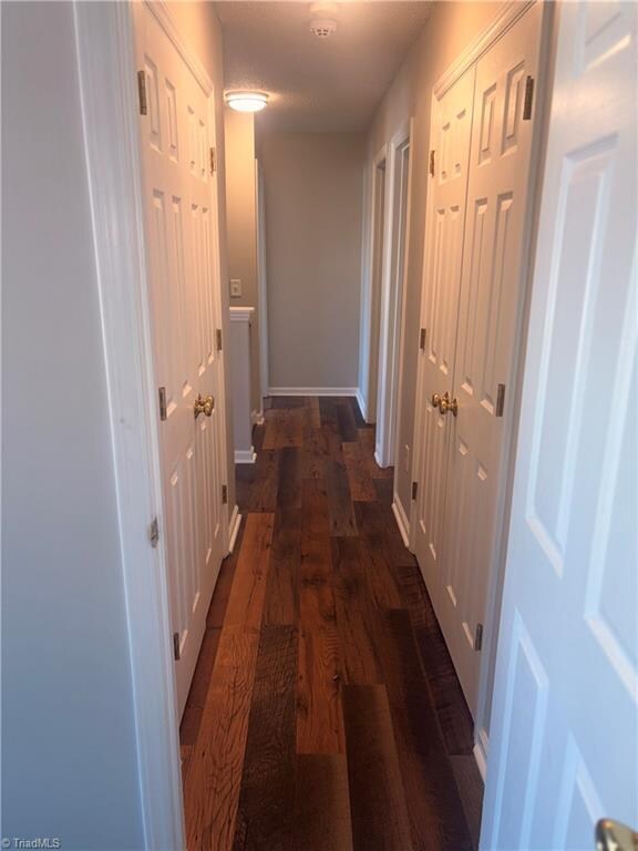 corridor with dark hardwood / wood-style floors