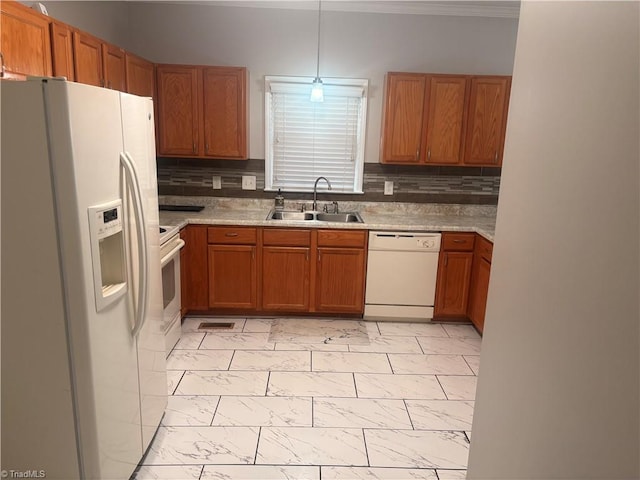 kitchen featuring backsplash, white appliances, sink, and pendant lighting