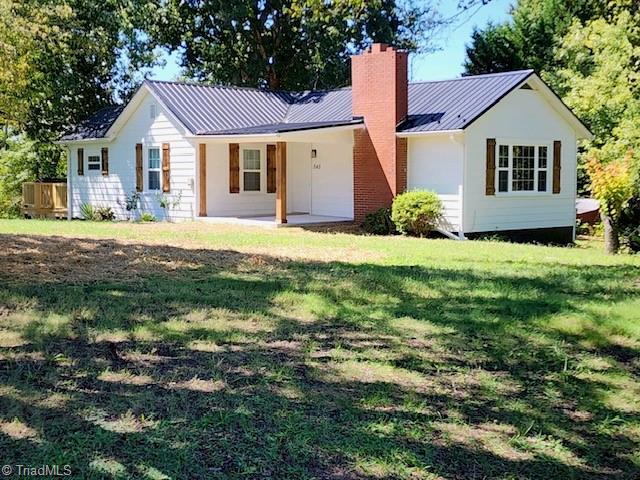 rear view of house featuring a yard