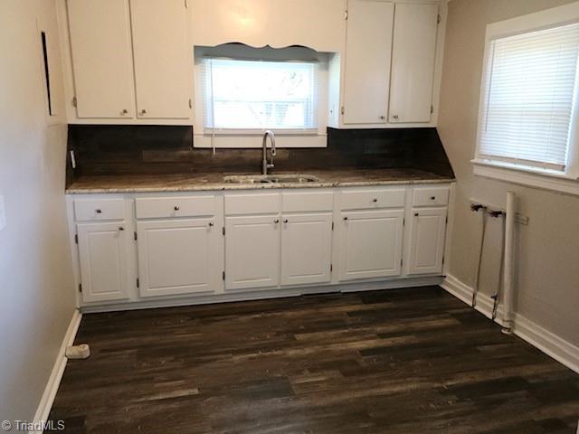 kitchen with dark wood-type flooring, decorative backsplash, sink, and white cabinets