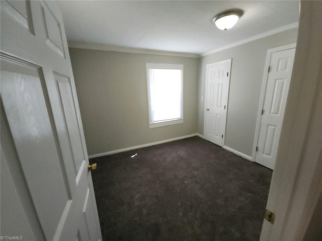 unfurnished bedroom featuring dark carpet and ornamental molding