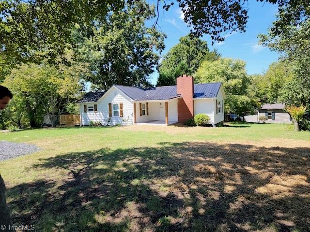 rear view of property with a yard