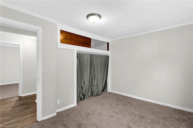 unfurnished bedroom with crown molding, a closet, and carpet flooring