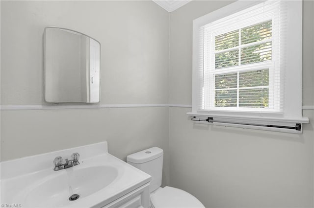 bathroom with ornamental molding, vanity, and toilet