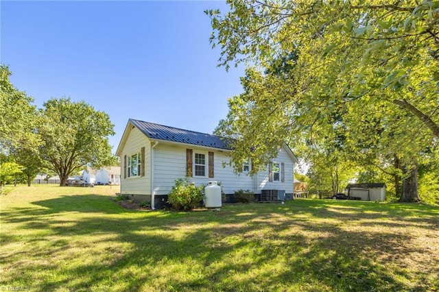 back of property featuring cooling unit, a lawn, and a storage unit