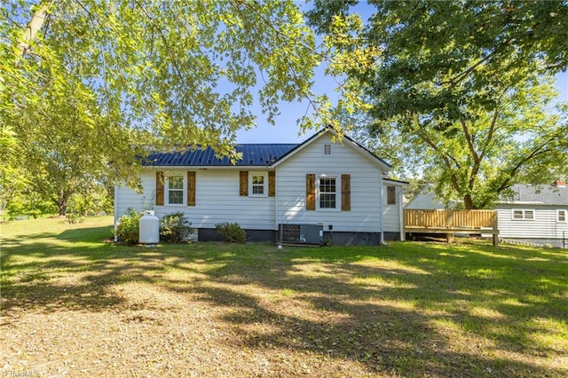 back of property featuring a wooden deck, a lawn, and central AC unit