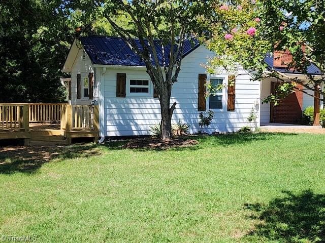 exterior space with a wooden deck and a lawn