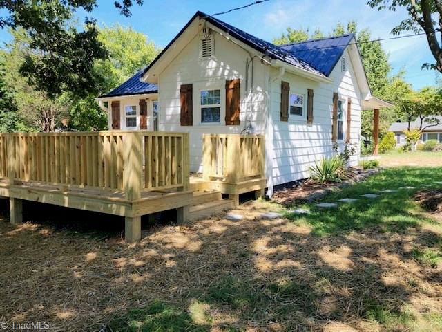 rear view of property featuring a wooden deck