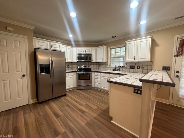4727 Eagle Path, Winston-Salem, NC 27127 - kitchen featuring stainless steel appliances, tile countertops, a peninsula, dark wood finished floors, and decorative backsplash
