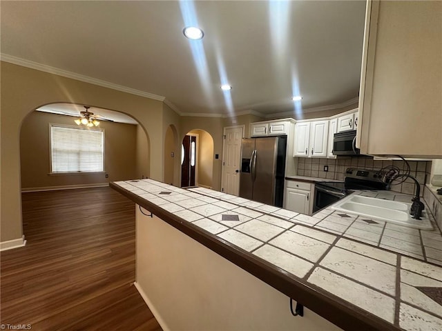 4727 Eagle Path, Winston-Salem, NC 27127 - kitchen with appliances with stainless steel finishes, arched walkways, tile countertops, a sink, and dark wood-type flooring