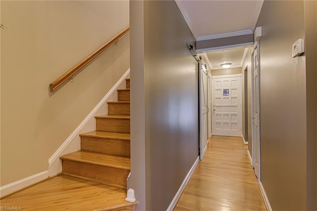 staircase with crown molding, wood finished floors, and baseboards