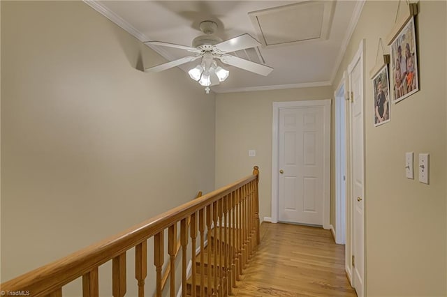 hall featuring baseboards, an upstairs landing, light wood-style floors, and crown molding