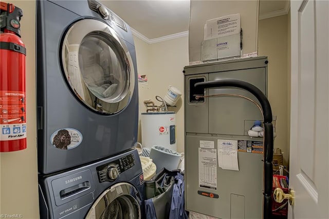 washroom with laundry area, ornamental molding, stacked washer / drying machine, and water heater