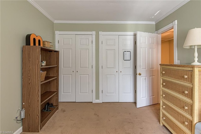 bedroom with carpet flooring, baseboards, multiple closets, and ornamental molding