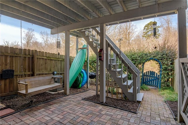 view of patio featuring stairway, fence private yard, and a gate