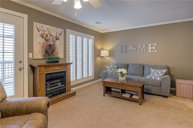 carpeted living room featuring visible vents, a fireplace with raised hearth, baseboards, ornamental molding, and a ceiling fan