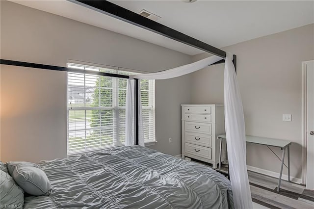 6801 Hanesbrook Cir Unit 104, Clemmons, NC 27012 - bedroom with multiple windows, wood finished floors, and baseboards