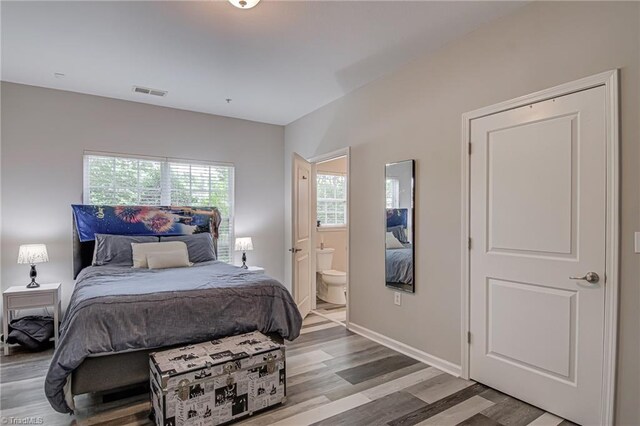 6801 Hanesbrook Cir Unit 104, Clemmons, NC 27012 - bedroom with wood finished floors, connected bathroom, and baseboards