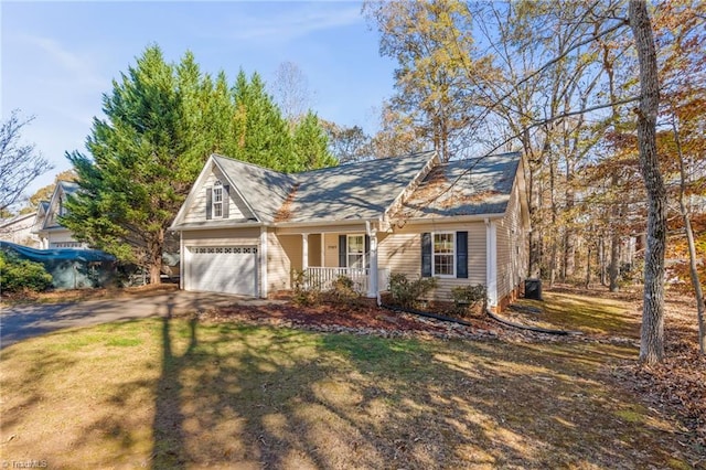 view of front of property featuring covered porch, a front yard, and a garage