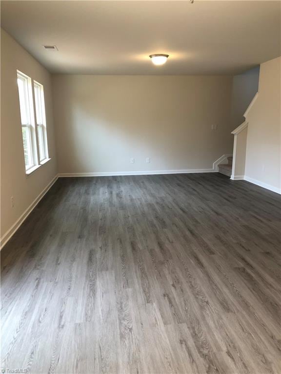 2866 Tysinger Rd, Denton, NC 27239 - unfurnished living room with dark wood-style flooring, baseboards, and stairway
