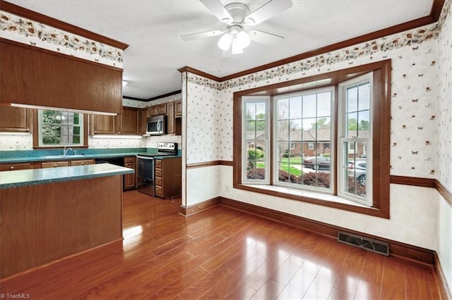 206 Swaim Ct, Salisbury, NC 28147 - kitchen with appliances with stainless steel finishes, wallpapered walls, baseboards, ornamental molding, and a sink