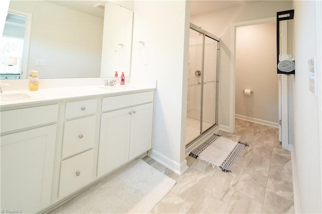 full bath featuring a sink, double vanity, and a shower stall