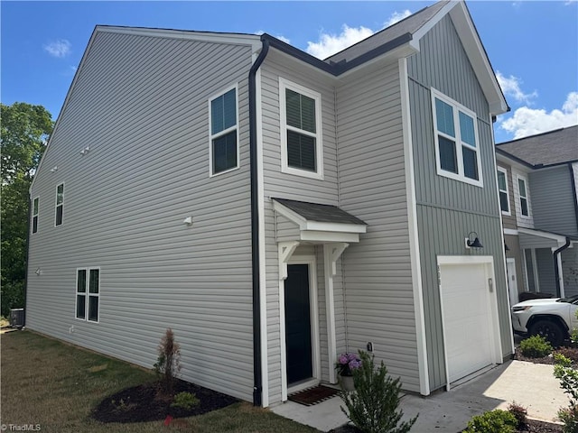 exterior space with central AC unit and a garage