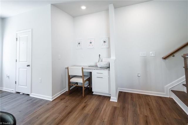 unfurnished office with built in desk, recessed lighting, baseboards, and wood finished floors
