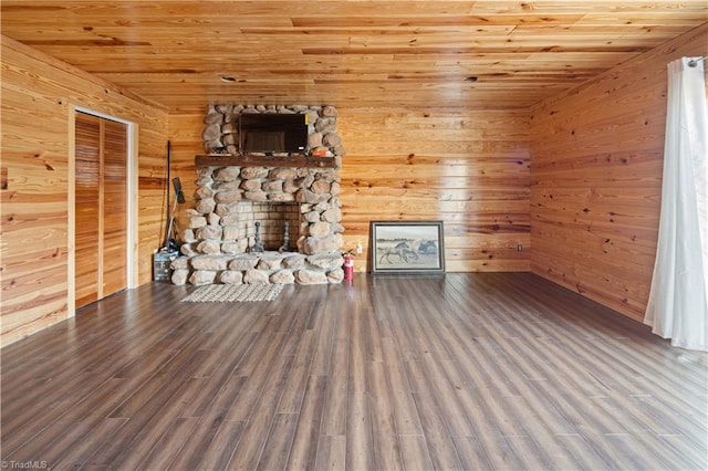 unfurnished living room featuring a fireplace, hardwood / wood-style floors, wooden ceiling, and wood walls