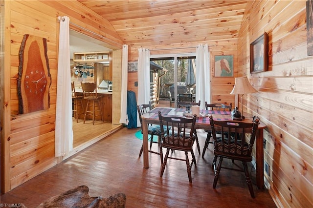 dining area featuring wood walls, wood ceiling, lofted ceiling, and hardwood / wood-style flooring