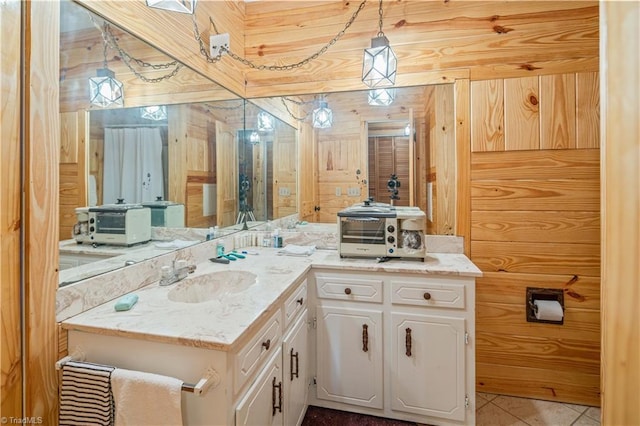 bathroom featuring wooden walls, tile patterned flooring, and vanity