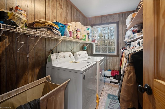 washroom featuring washer and dryer and wooden walls