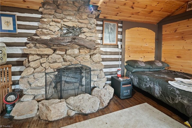 unfurnished bedroom with wooden ceiling, dark hardwood / wood-style flooring, wood walls, vaulted ceiling, and a fireplace