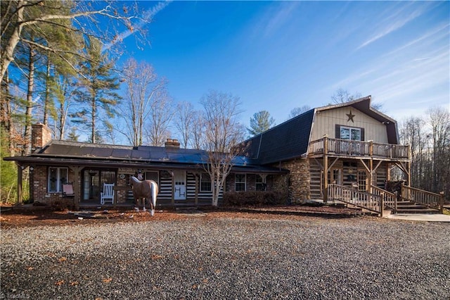 log home with solar panels and a porch