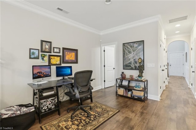 office with visible vents, baseboards, wood finished floors, and ornamental molding