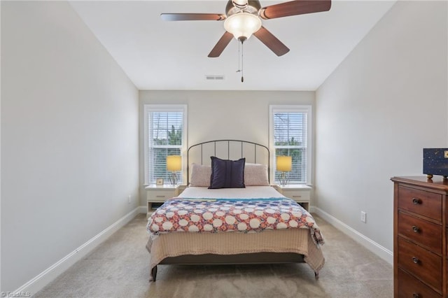 bedroom featuring baseboards, multiple windows, and light colored carpet