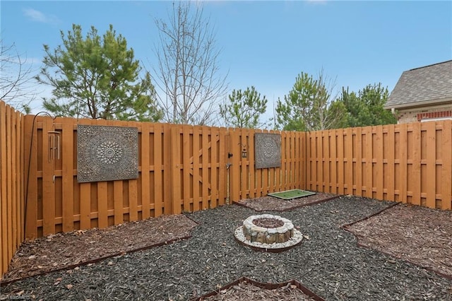 view of yard with a fenced backyard and an outdoor fire pit