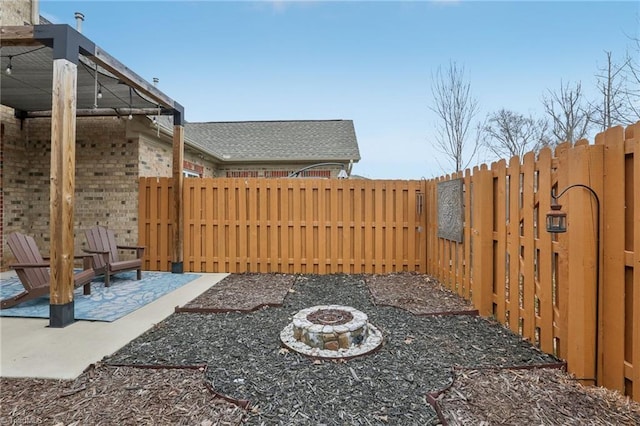 view of yard with a patio, a fenced backyard, and an outdoor fire pit