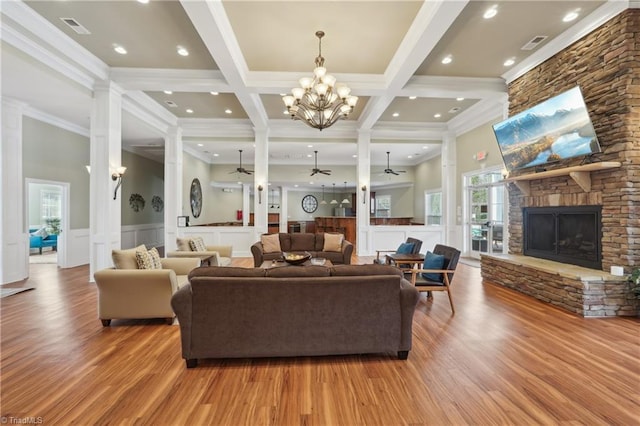 living room with visible vents, ceiling fan with notable chandelier, a fireplace, and beamed ceiling