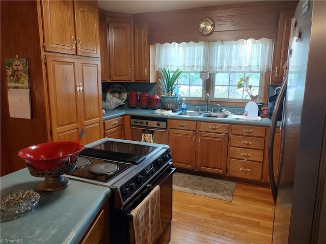 345 Anderson Rd, Eden, NC 27288 - kitchen with freestanding refrigerator, brown cabinetry, light wood-style flooring, a sink, and black / electric stove