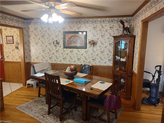345 Anderson Rd, Eden, NC 27288 - dining room with ceiling fan, light wood-style flooring, a textured ceiling, wainscoting, and wallpapered walls