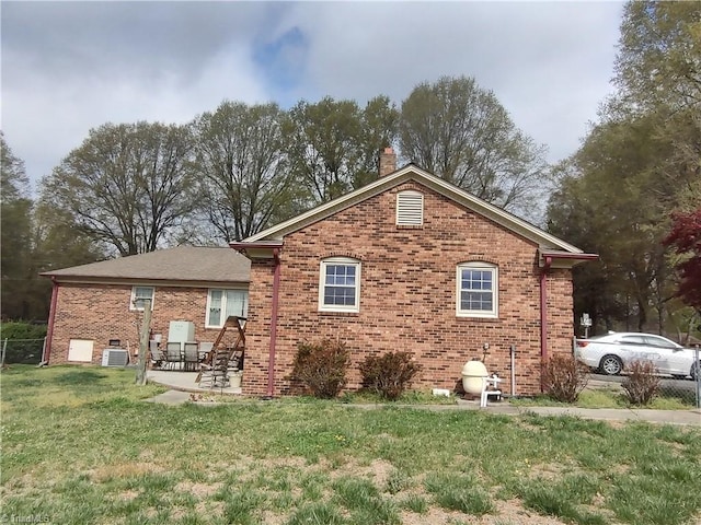 345 Anderson Rd, Eden, NC 27288 - back of house with central AC, a lawn, a patio area, brick siding, and a chimney