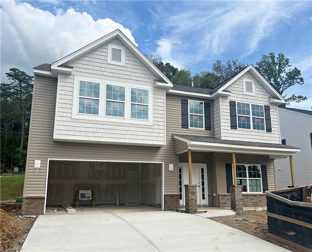 craftsman-style home featuring a garage, covered porch, and concrete driveway